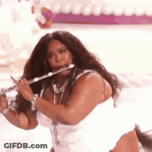 Woman In White Dress Playing Flute On Stage GIF