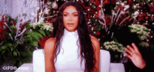 Woman In White Dress Sitting By Christmas Tree GIF