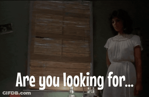 Woman In White Dress Standing At Window Saying Are You Looking For GIF