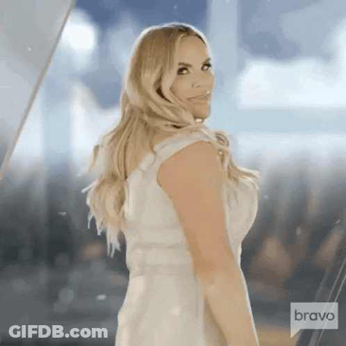 Woman In White Dress Standing Before Bravo Sign GIF