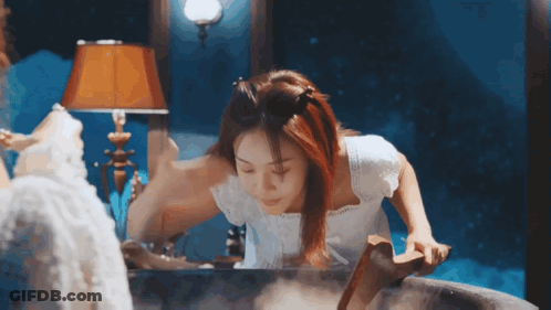 Woman In White Dress Standing In Bathtub Looking In Mirror GIF