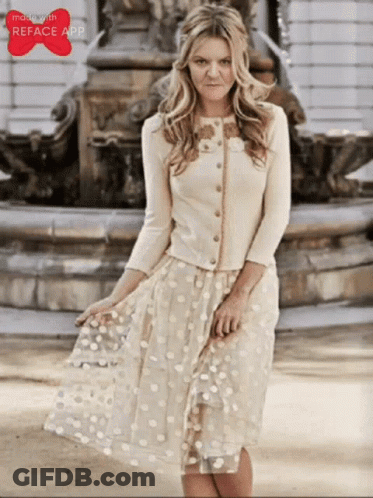 Woman In White Dress Standing In Front Of Fountain With Reface App Logo GIF