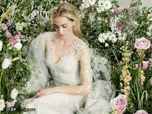 Woman In White Dress Surrounded By Flowers GIF