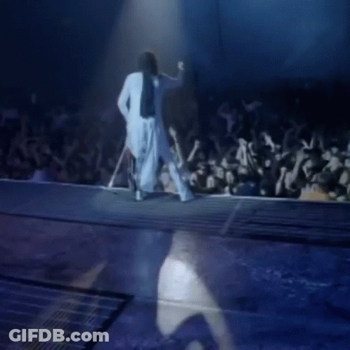 Woman In White Dress Walking Down Stage Before Crowd GIF