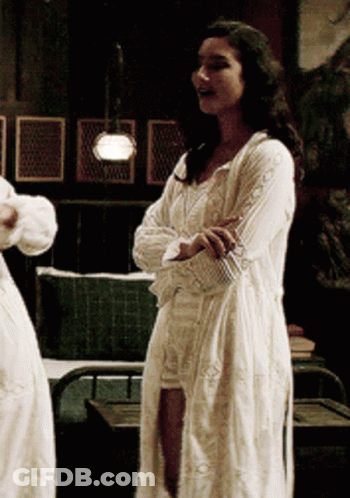 Woman In White Dress With Arms Crossed In Dark Room GIF