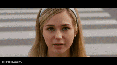 Woman In White Headband And Earrings Looking At Camera GIF