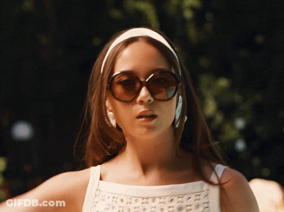 Woman In White Headband And Sunglasses Looking At Camera GIF