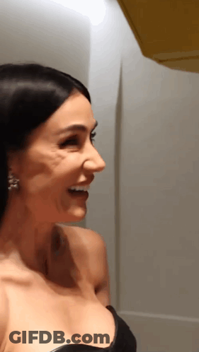 Woman In White Jacket At Microphone In Dark Room GIF