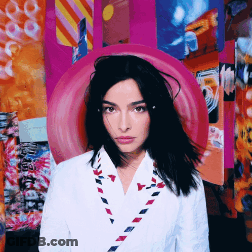Woman In White Jacket With Red White Blue Envelope Necklace GIF