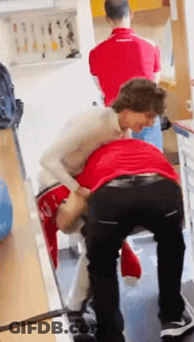 Woman In White Lifting Man In Red GIF