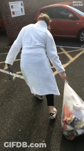 Woman In White Robe Carrying Trash Bag GIF