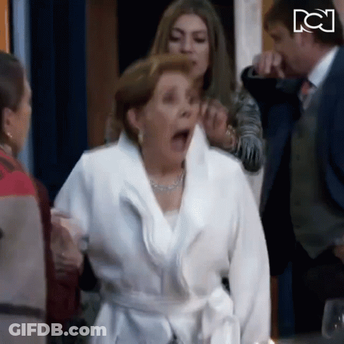 Woman In White Robe With Mouth Open Surrounded By People GIF
