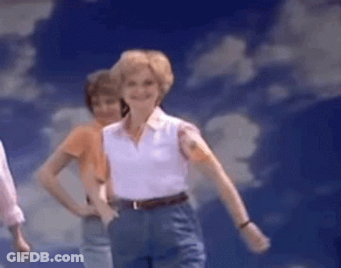 Woman In White Shirt And Blue Pants Dancing Under Blue Sky GIF