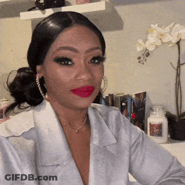Woman In White Shirt And Red Lipstick Sitting By Candle GIF