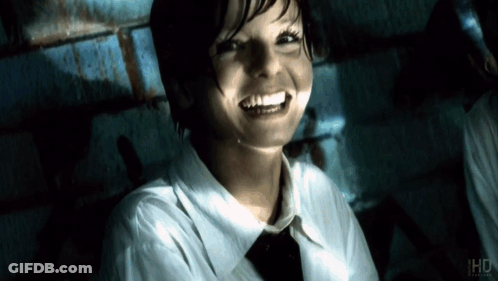 Woman In White Shirt And Tie Smiling In Front Of IHD Sign GIF