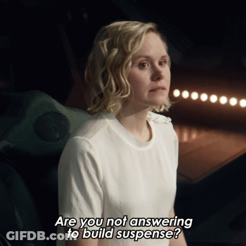 Woman In White Shirt Asking If She Is Answering To Build Suspense GIF