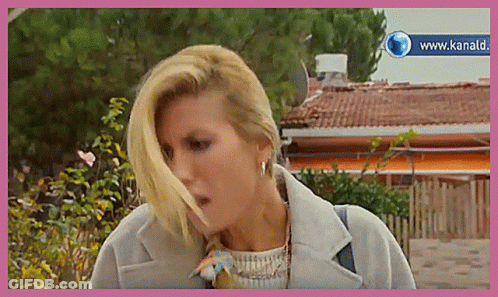 Woman In White Shirt At Table Saying E Questo GIF