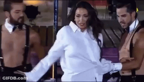 Woman In White Shirt Between Two Shirtless Men In Suspenders GIF
