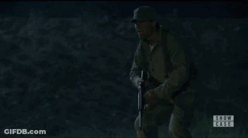 Woman In White Shirt Pointing Gun At Man In Showcase Ad GIF