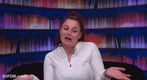 Woman In White Shirt Sitting By Bookshelf GIF