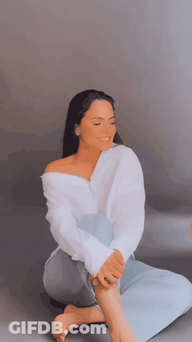 Woman In White Shirt Sitting Cross-Legged Eyes Closed GIF