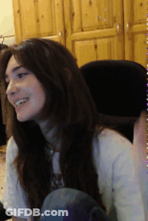 Woman In White Shirt Smiling In Front Of Wooden Cabinet GIF
