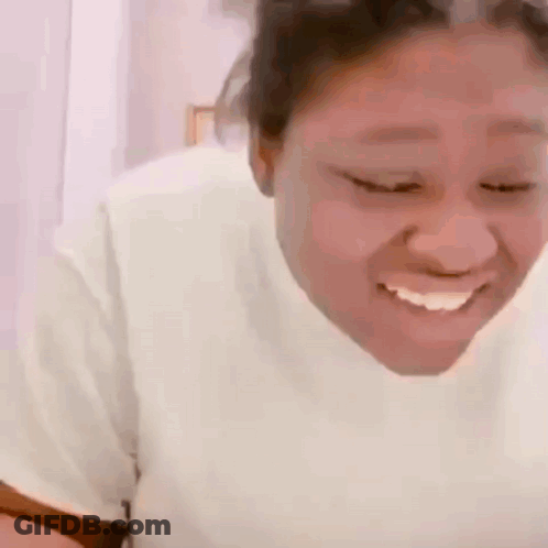 Woman In White Shirt Smiling Looking Down GIF