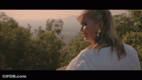 Woman In White Shirt Standing In Front Of Mountain GIF