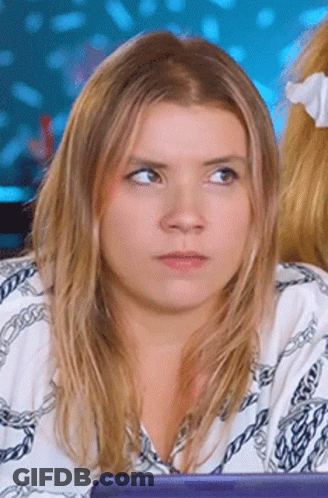 Woman In White Shirt With Chains Looking At Camera GIF