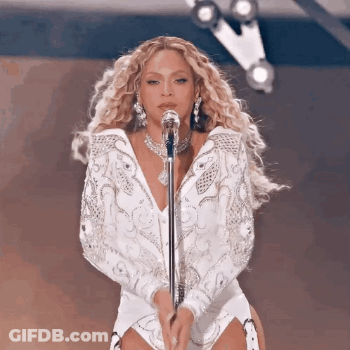 Woman In White Singing Into Microphone GIF