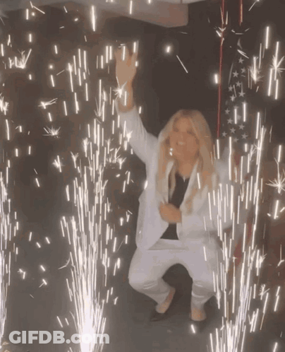 Woman In White Suit Dancing Fireworks GIF