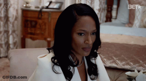 Woman In White Suit Sitting On Bed With Bet GIF