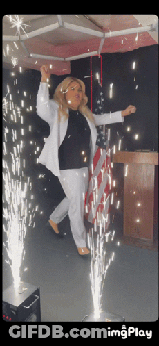 Woman In White Suit With Sparkler Podium GIF