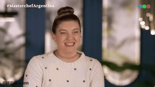 Woman In White Sweater And Bun Smiling With MasterChef Argentina Logo GIF