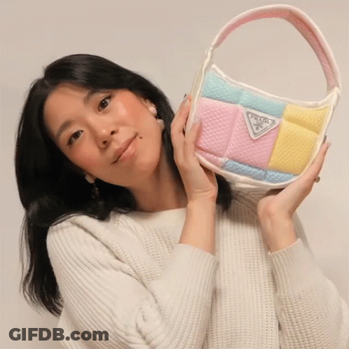 Woman In White Sweater Holding Prada Purse GIF
