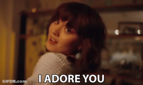 Woman In White Sweater Looking Over Shoulder Says I Adore You GIF