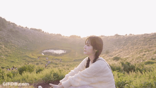 Woman In White Sweater Sitting In Field GIF