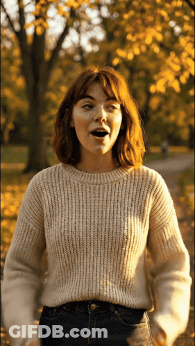 Woman In White Sweater Standing In Park GIF
