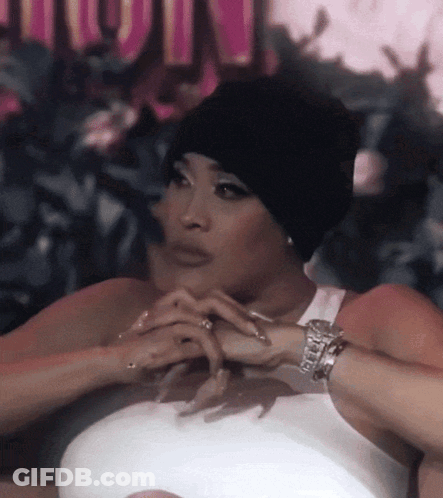 Woman In White Tank Top And Black Beanie With Hands Folded GIF