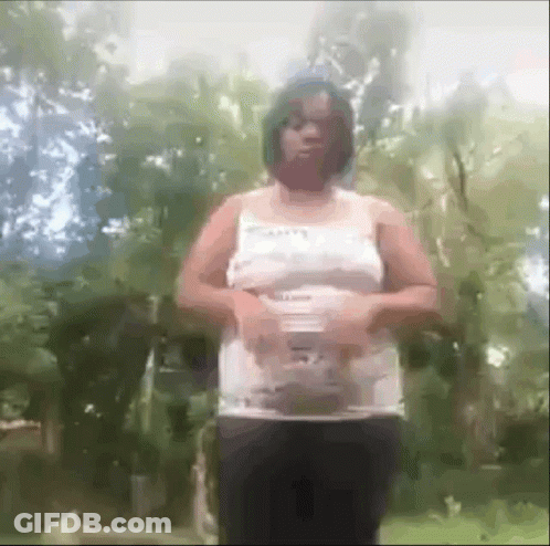 Woman In White Tank Top And Black Pants Standing In Forest GIF