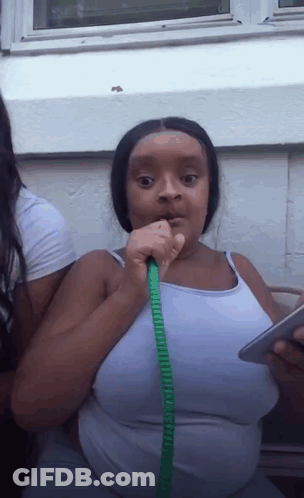Woman In White Tank Top Drinking From Green Hose GIF