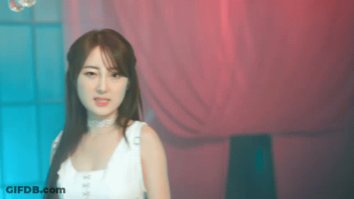 Woman In White Tank Top In Front Of Pink Curtain GIF