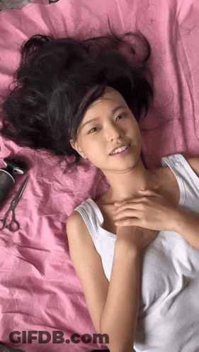 Woman In White Tank Top Laying On Bed GIF