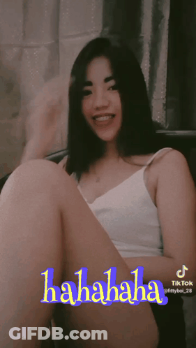 Woman In White Tank Top Sitting Cross-Legged With TikTok Hahaha Sticker GIF