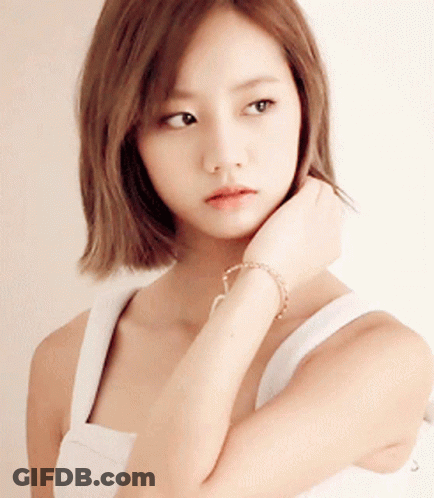 Woman In White Tank Top Touching Chin GIF