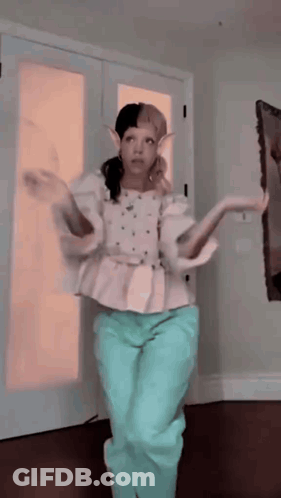 Woman In White Top And Blue Pants Dancing GIF