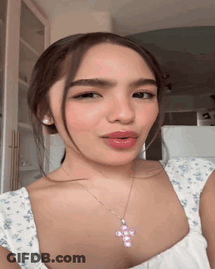 Woman In White Top And Pink Cross Necklace GIF