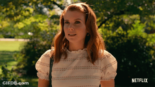 Woman In White Top Standing In Park With Netflix Logo GIF