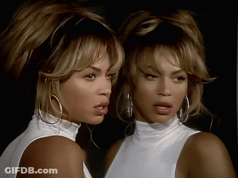 Woman In White Turtleneck Looking In Mirror GIF