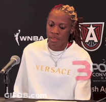 Woman In White Versace Shirt At Podium GIF